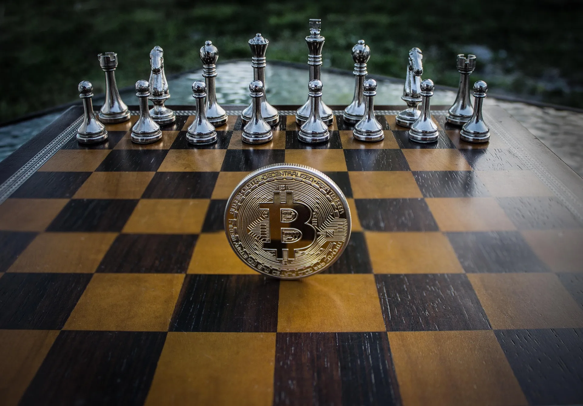 Bitcoin coin on a chessboard among chess pieces