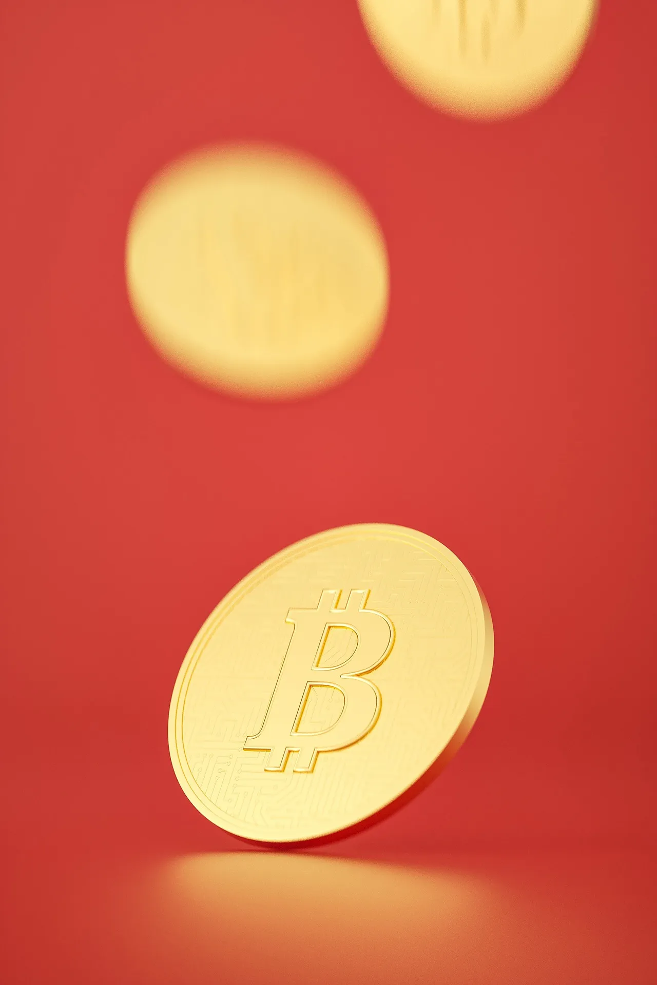 Gold Bitcoin coins falling against a red background